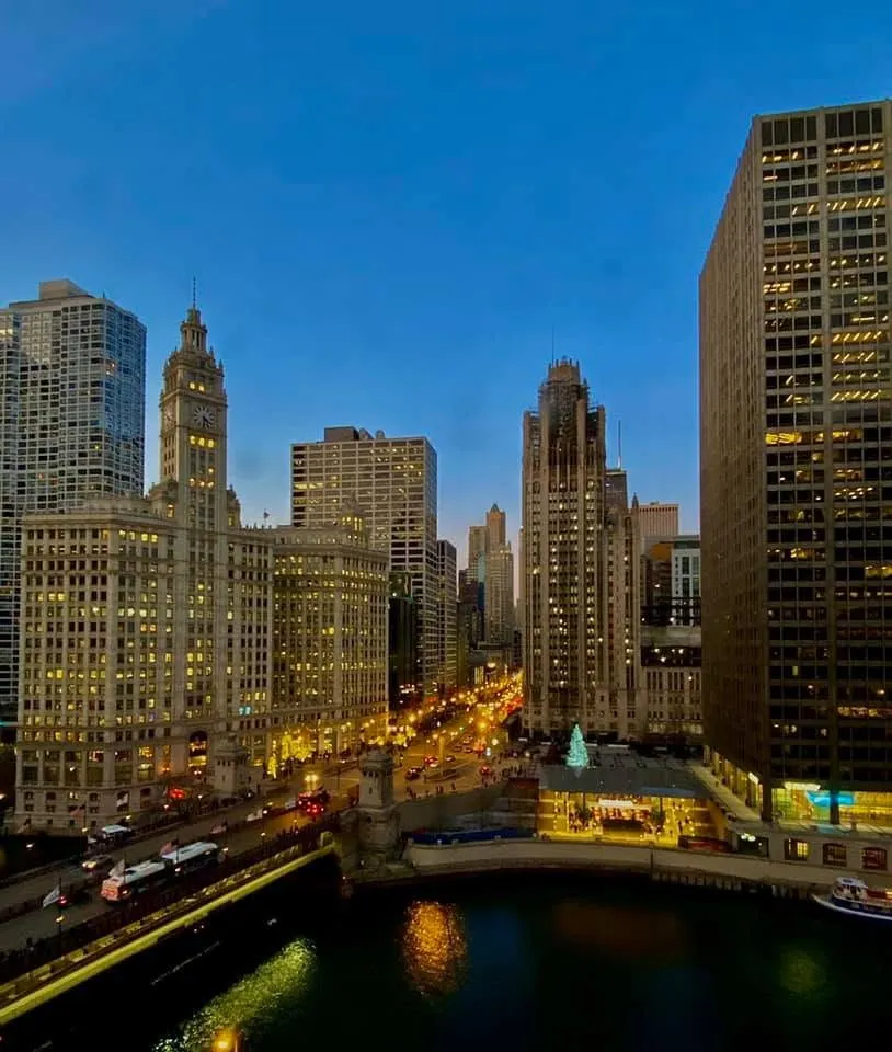 The Chicago River at blue hour, with the Wrigley Building, Tribune Tower and city lights along the riverbank