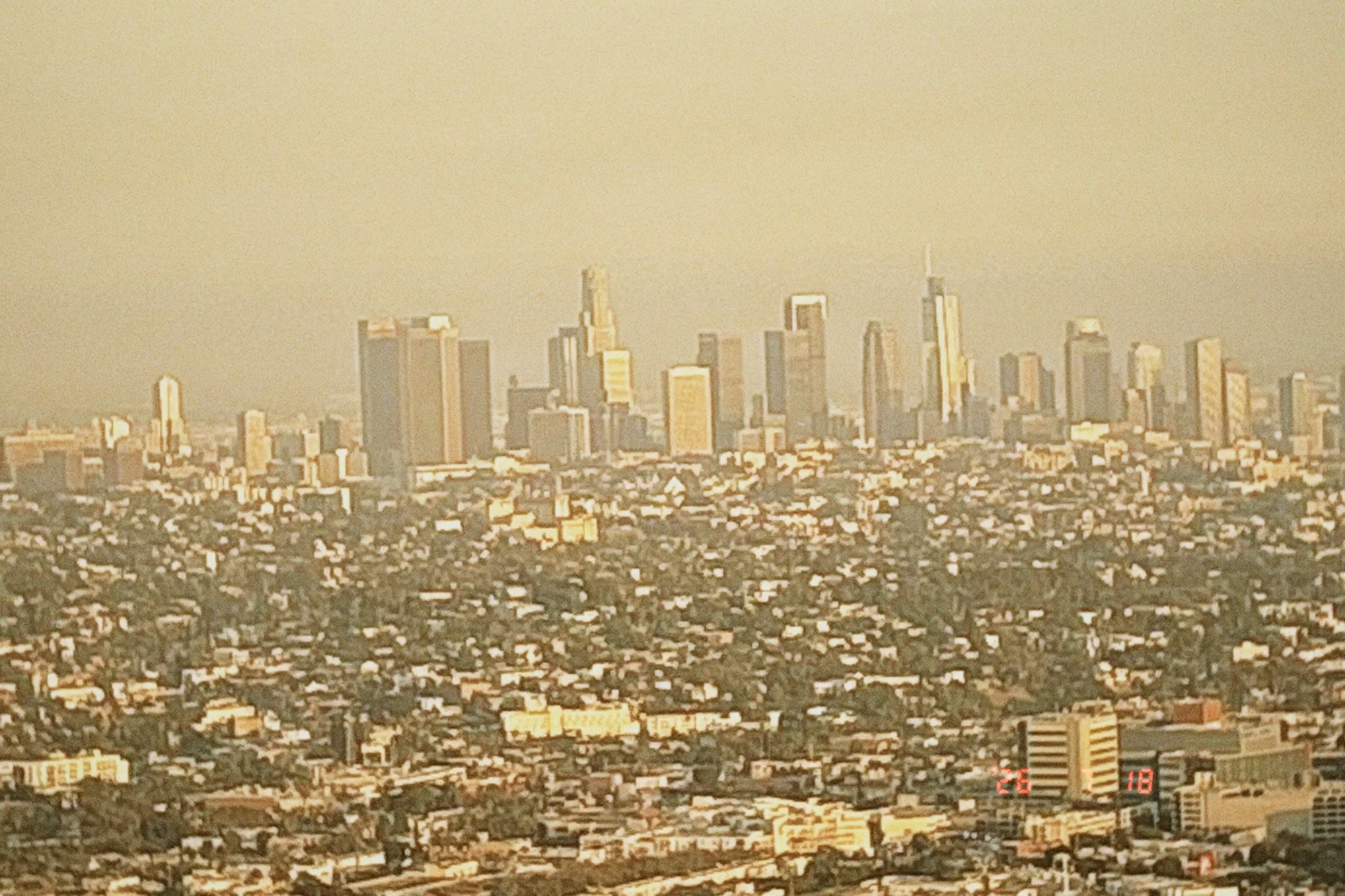 The downtown Los Angeles skyline rising out of a hazy sprawl of the city