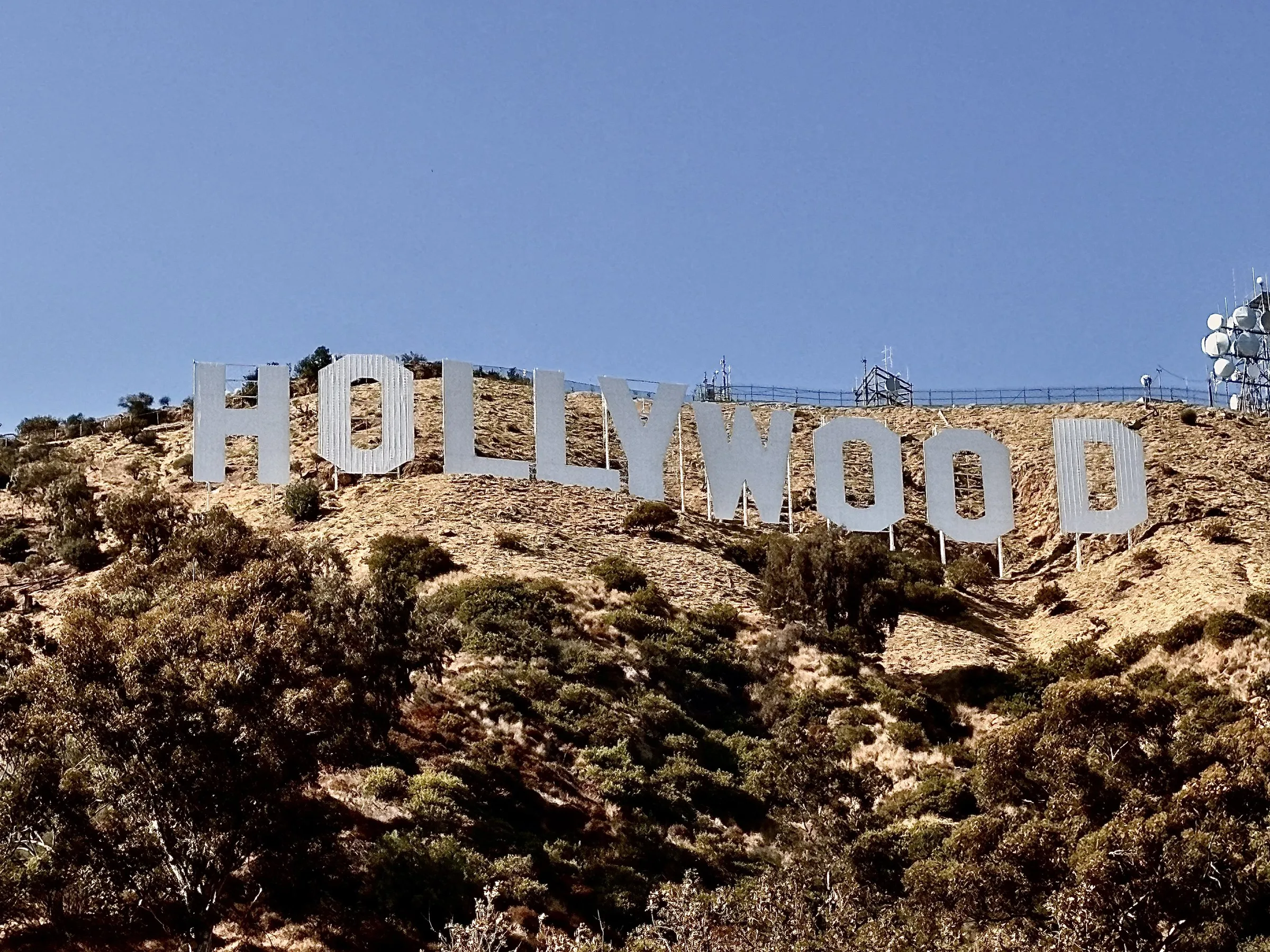 The Hollywood sign on the scrubby hillside under a clear blue sky
